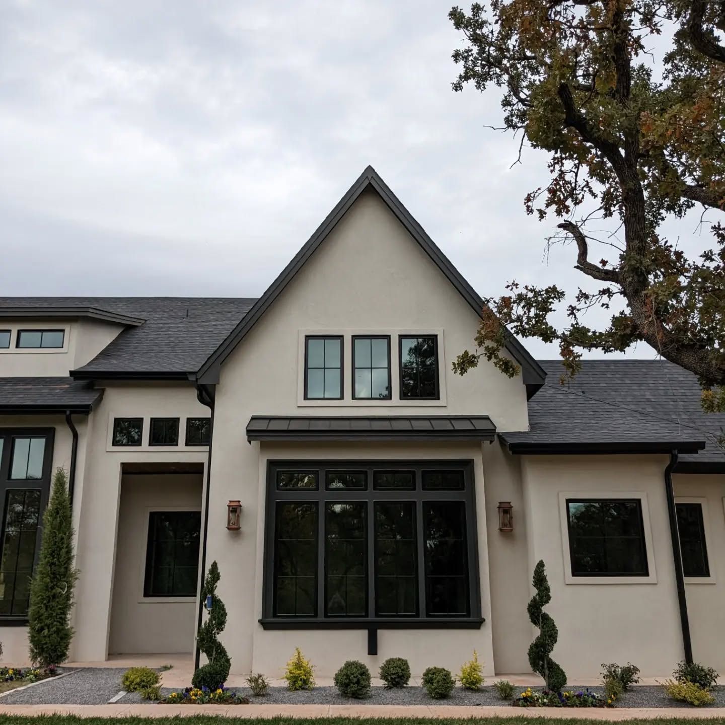 A white house with black windows and a black roof