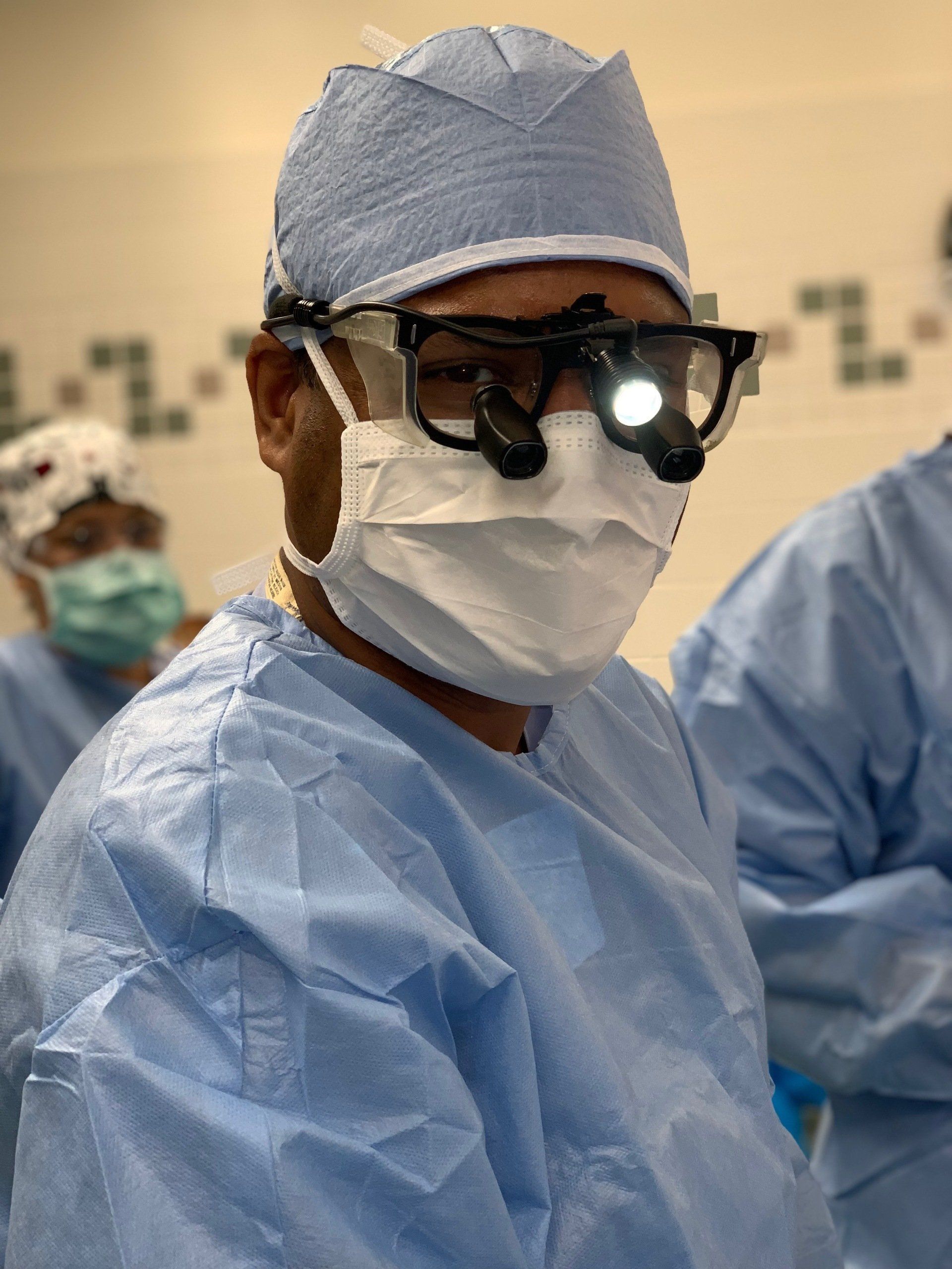 Photo of Dr. Sunishka Wimalawansa in the operating room wearing scrub gown and medical loupes