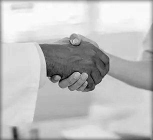 closeup of surgeon shaking hands with patient