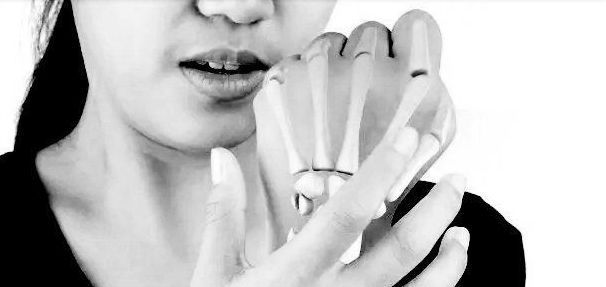 Black and white closeup photo of a woman's hand with bone illustration overlay