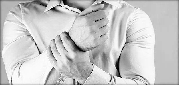 closeup of man holding injured wrist