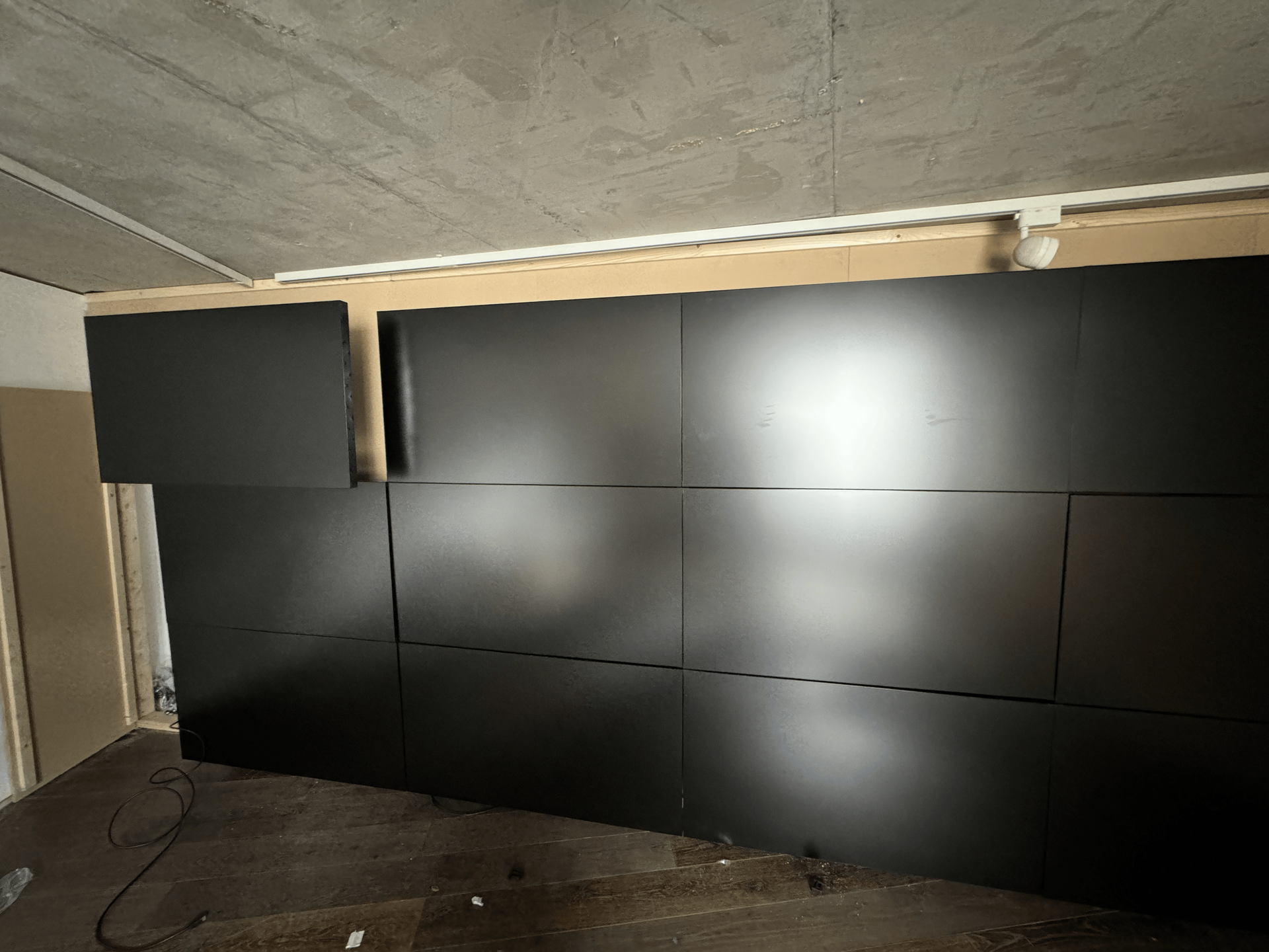 A wall with a lot of black tiles on it