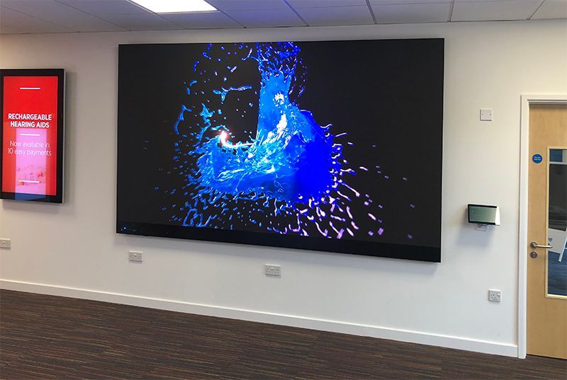 A large screen is hanging on a wall in a room.