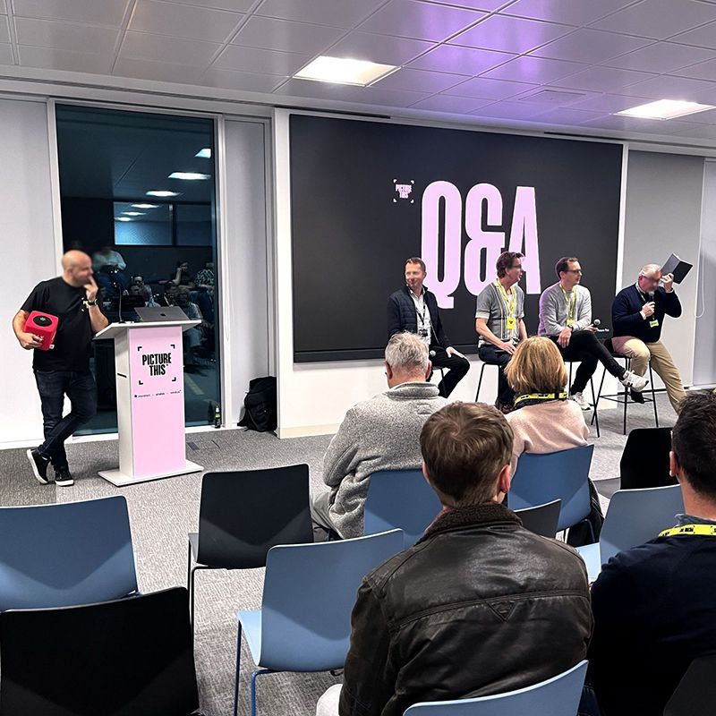 A group of people are sitting in chairs in front of a sign that says q & a