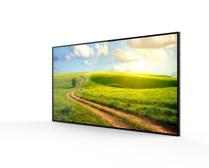 A flat screen tv with a picture of a field and a dirt road on it.
