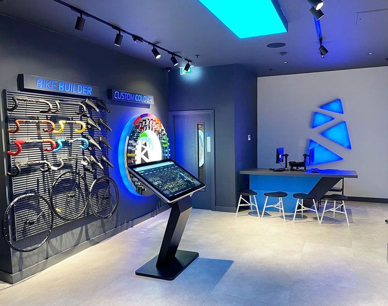 A room with a table and a display of bicycles on the wall.
