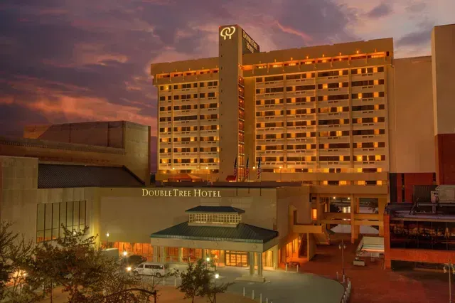 DoubleTree Hotel exterior building illuminated at dusk with a warm sunset sky in the background.