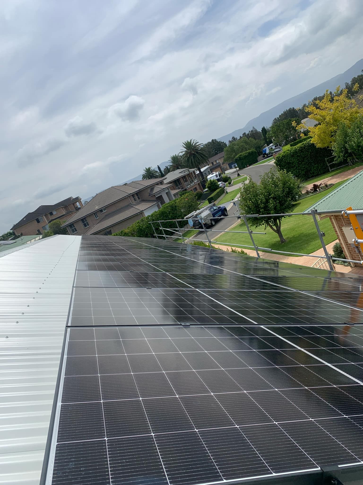 Tilted View of a Solar Panel Roof Beside a Parking Lot — Rapidcool Air Conditioning & Electrical In Dapto, NSW