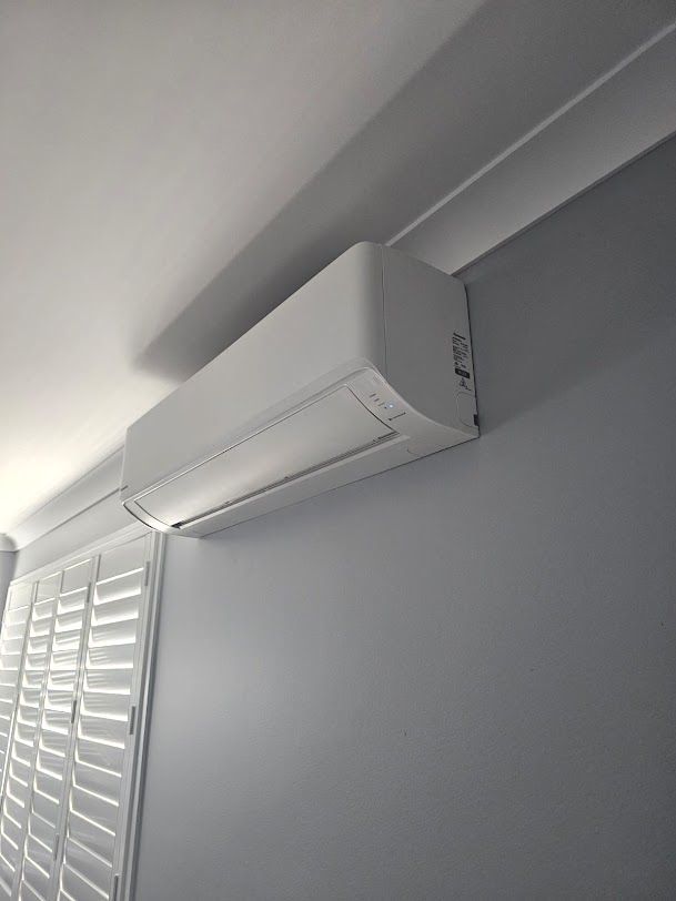A white air conditioning installed on a grey wall