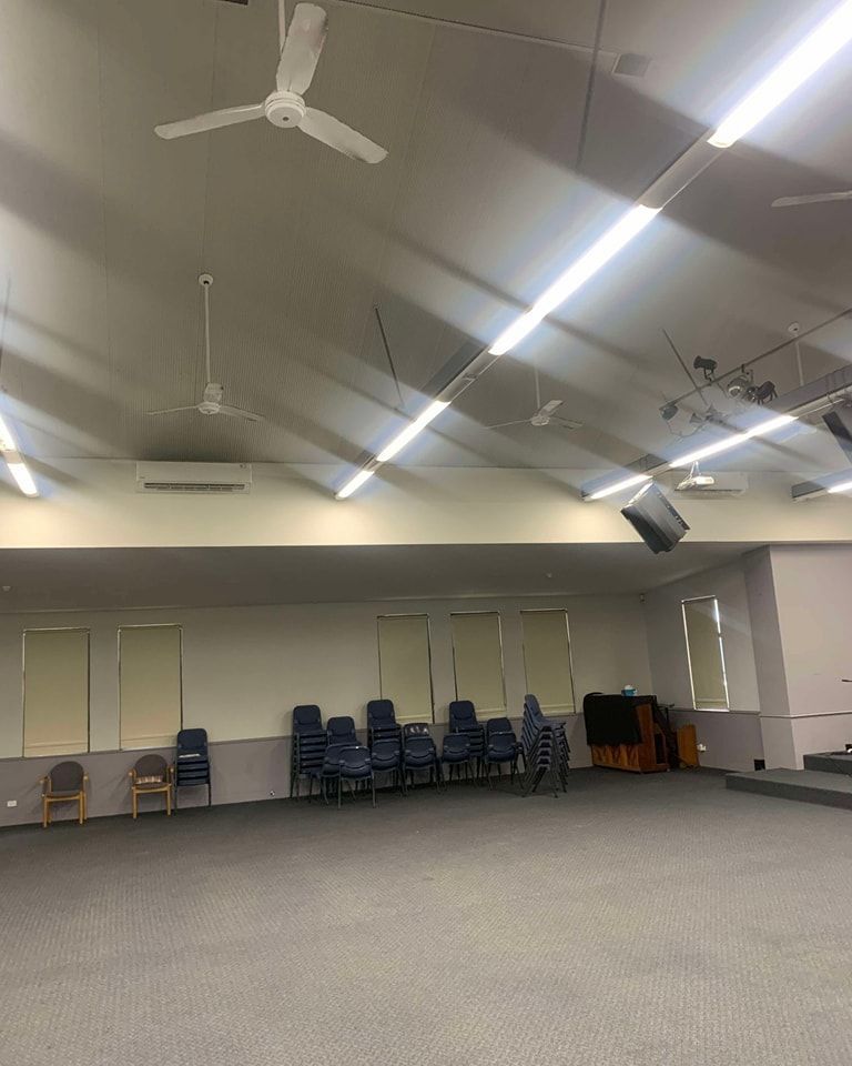 A Large Empty Room With Chairs And A Ceiling Fan — Rapidcool Air Conditioning & Electrical In Dapto, NSW