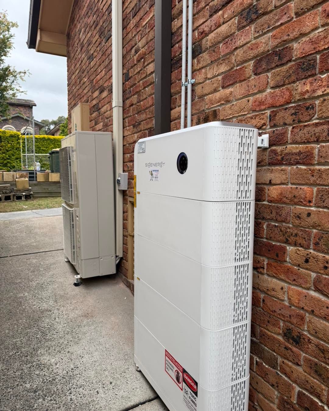 White Utility Cabinets Mounted Beside a Brick House Wall — Rapidcool Air Conditioning, Electrical & Solar In Thirroul, NSW