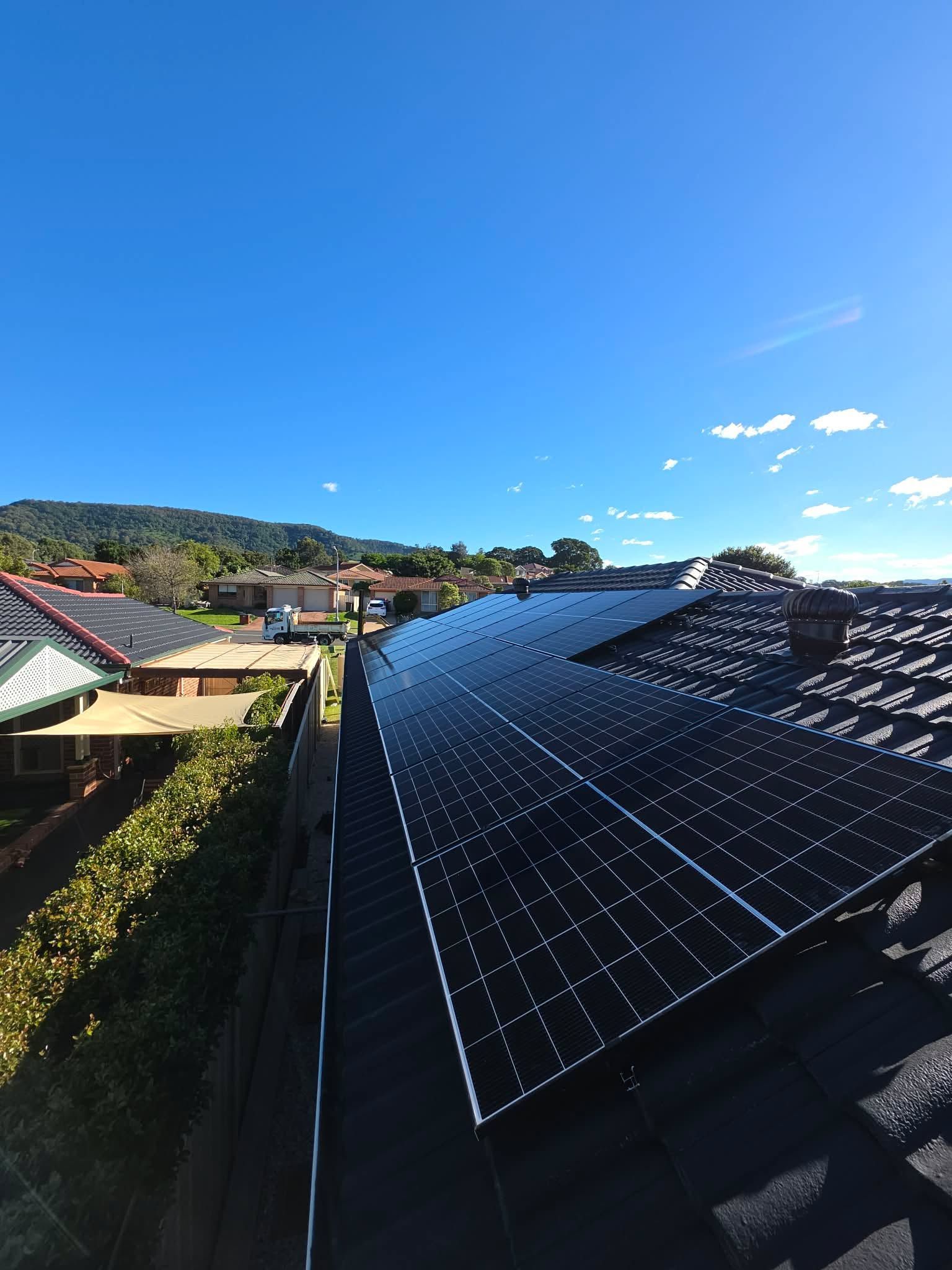 Solar Panels on a Rooftop Under a Clear Blue Sky — Rapidcool Air Conditioning, Electrical & Solar In Shellharbour, NSW