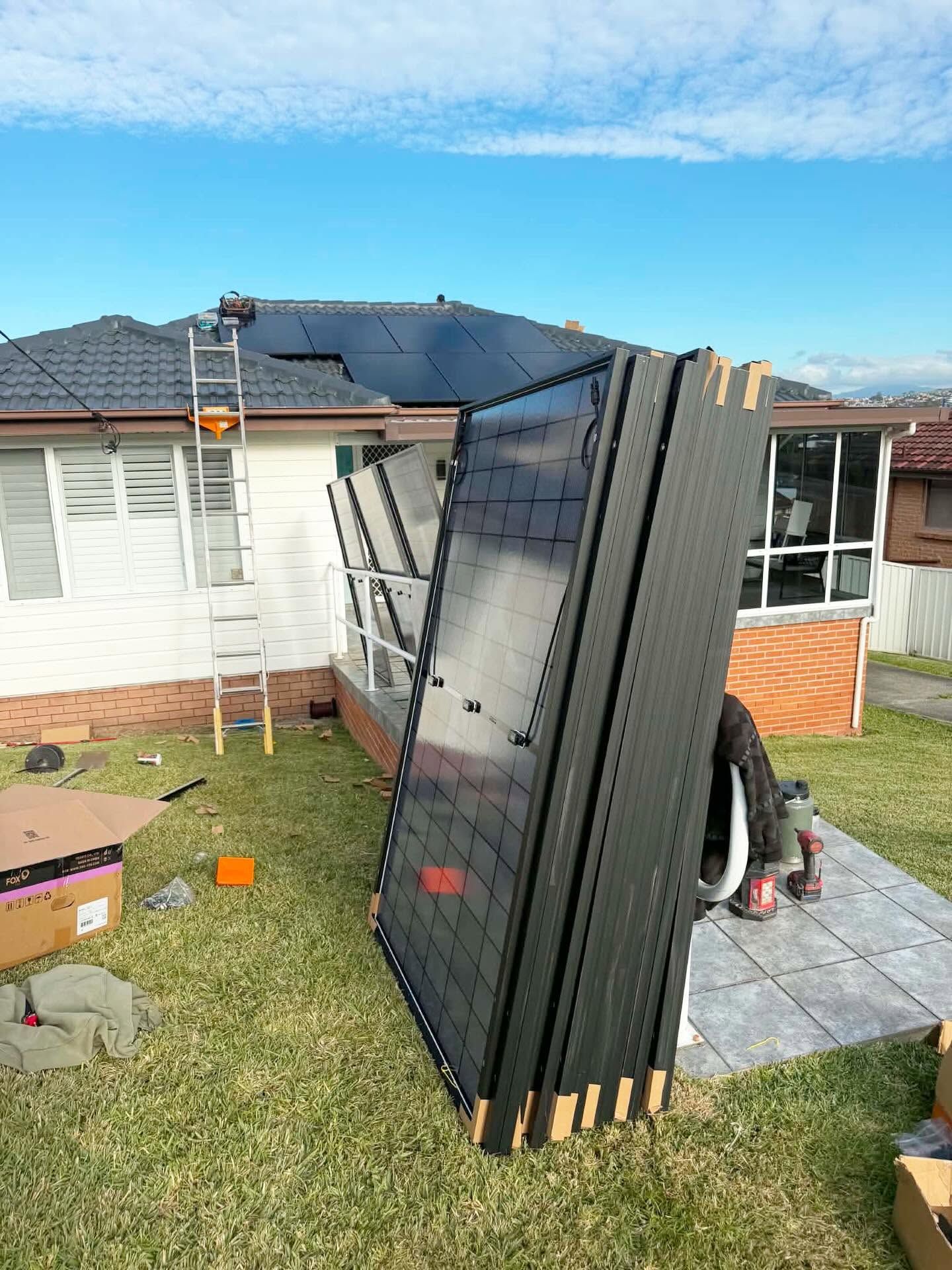 Stacked Black Panels Leaning in a Backyard — Rapidcool Air Conditioning & Electrical In Unanderra, NSW