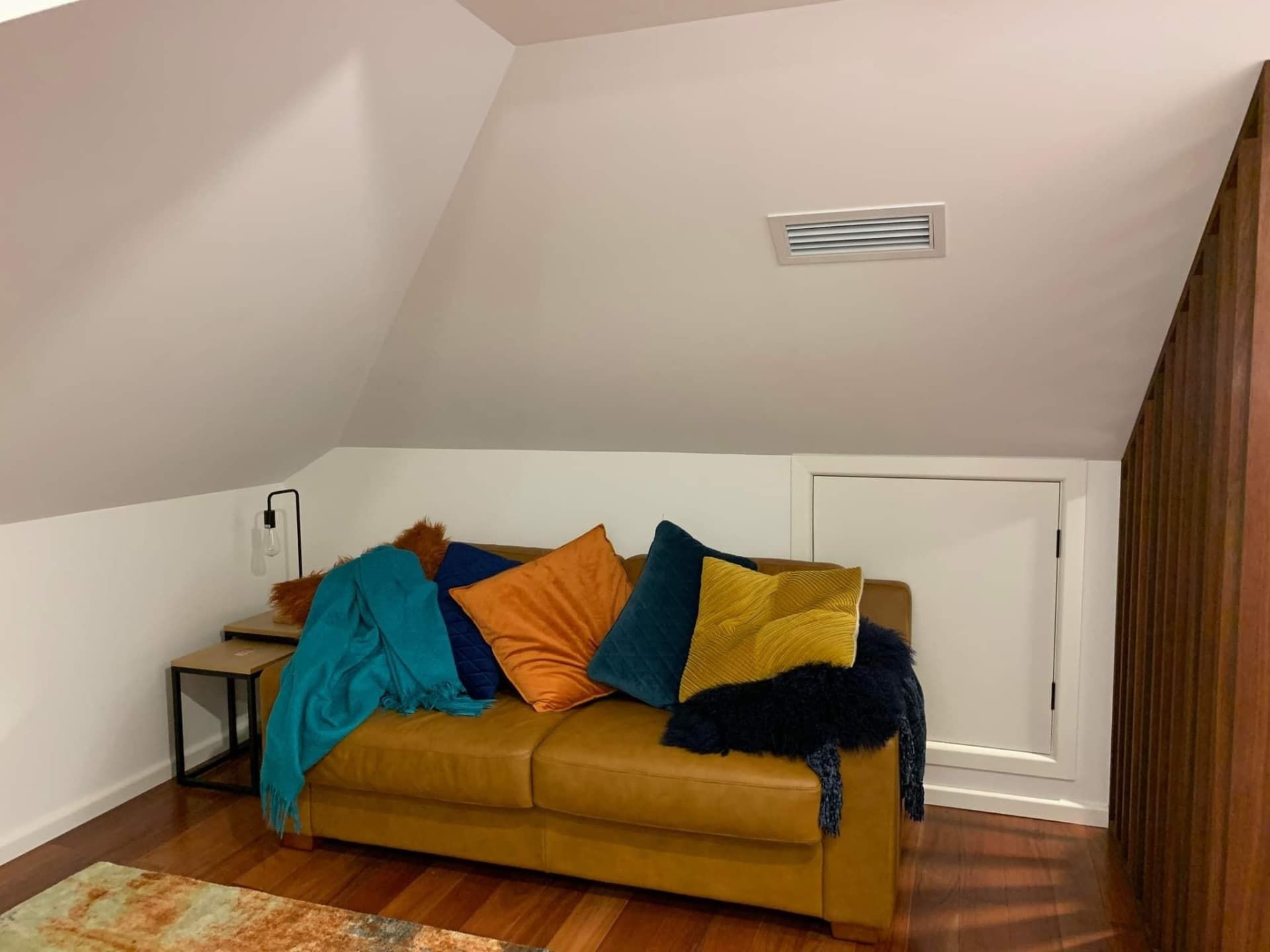 Small Attic Bedroom With a Mustard-yellow Couch — Rapidcool Air Conditioning & Electrical In Illawarra, NSW