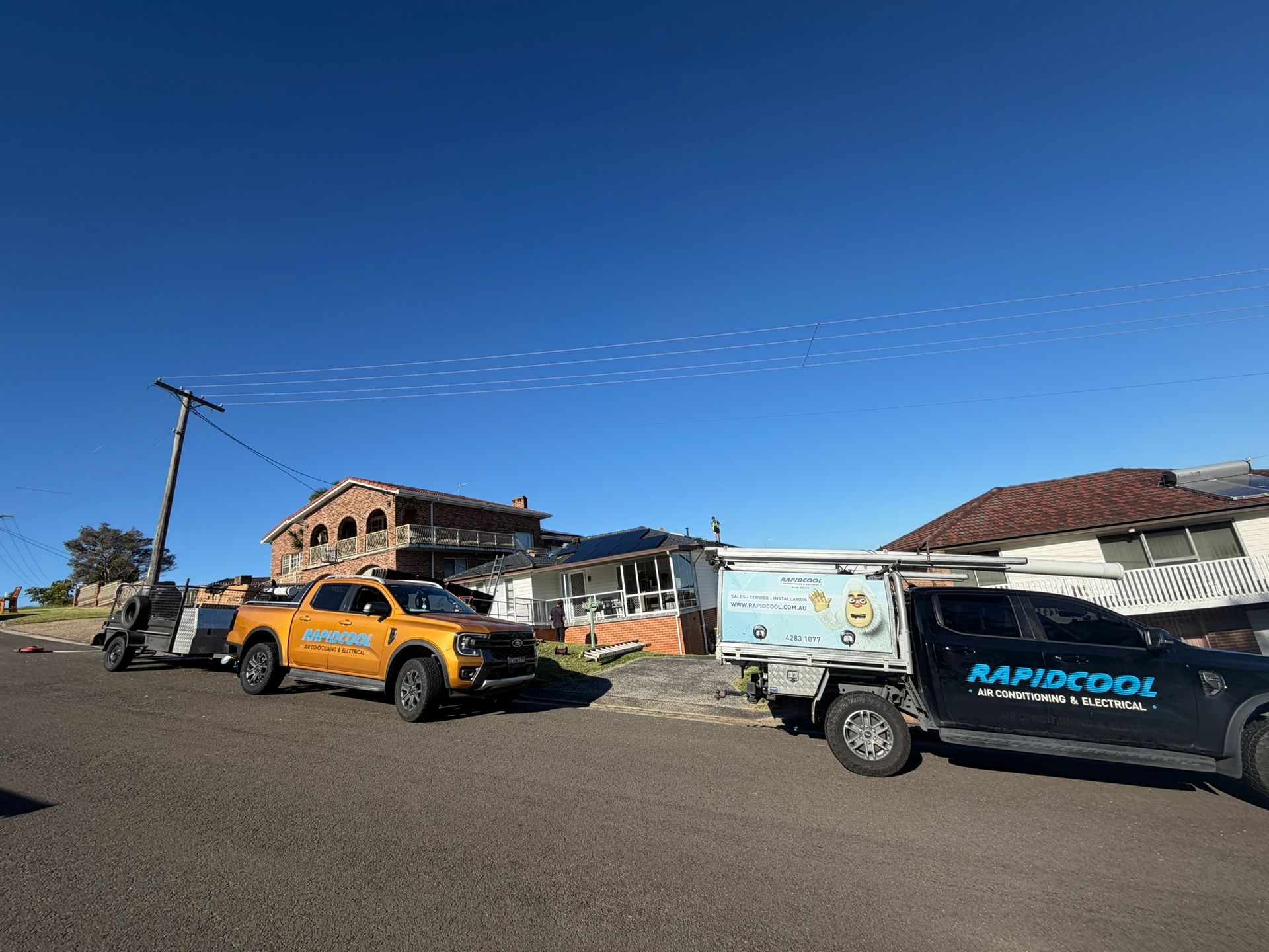 Orange Pickup and Utility Truck Parked by a Partly Built House — Rapidcool Air Conditioning, Electrical & Solar In Dapto, NSW