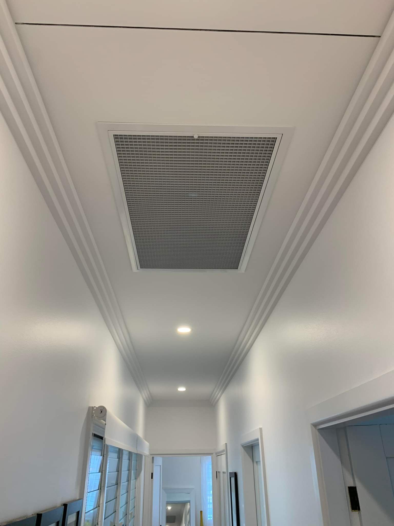 A White Air Conditioner Is Hanging From The Ceiling In A Room — Rapidcool Air Conditioning, Electrical & Solar In Dapto, NSW