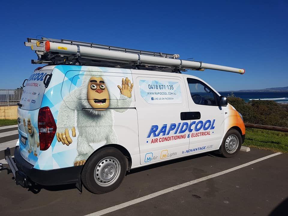 A Mitsubishi Air Conditioner Is Being Repaired On A Brick Sidewalk — Rapidcool Air Conditioning & Electrical In Dapto, NSW