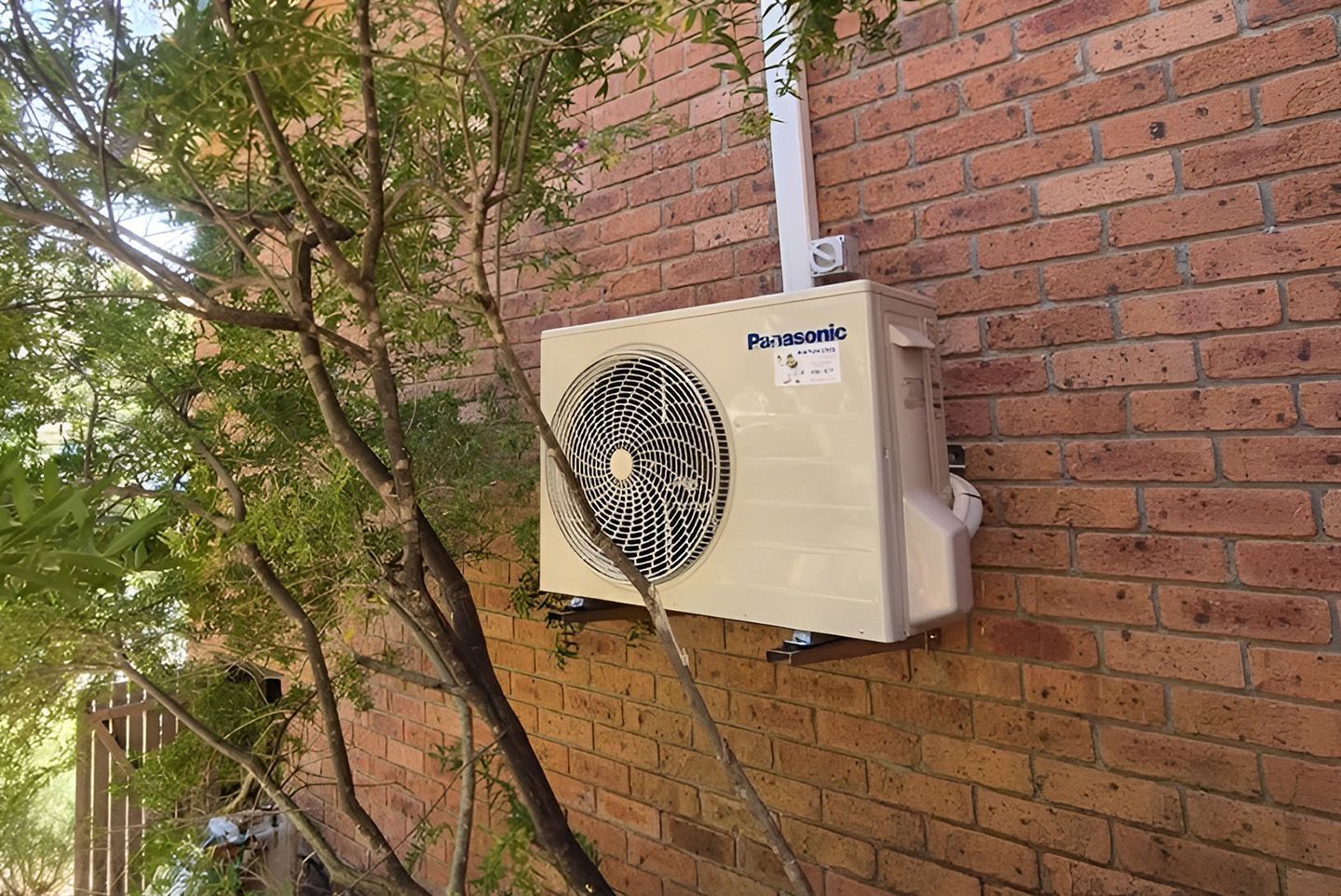 A Panasonic Outdoor Air Conditioning Unit Mounted On A Brick Wall