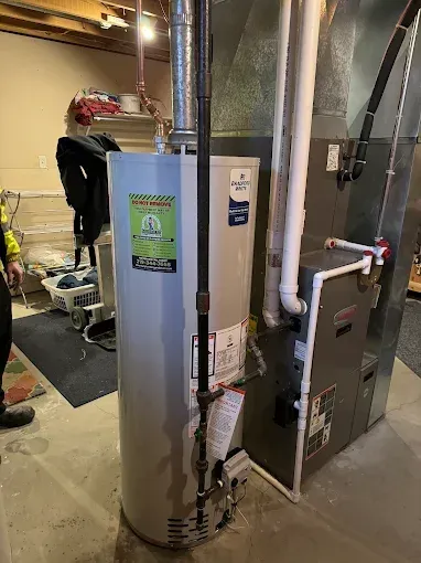 Plumber installing a water heater in a utility room