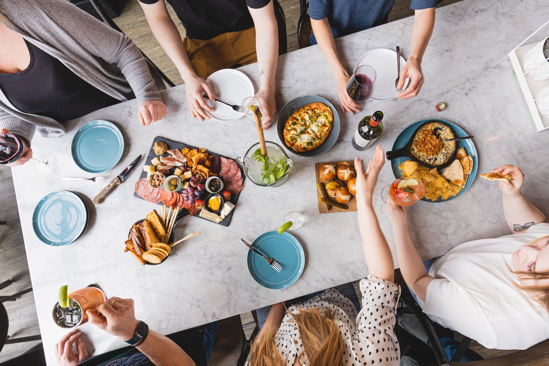 A group of people are sitting around a table eating food.