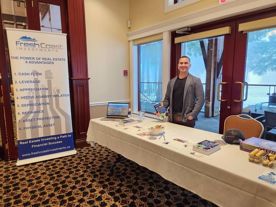 A man is standing in front of a table with a sign on it.