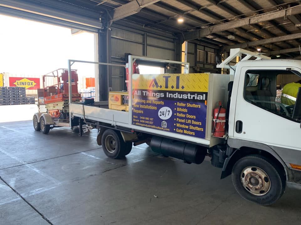 White Truck Towing a Lift in a Warehouse — All Things Industrial in Mackay, QLD