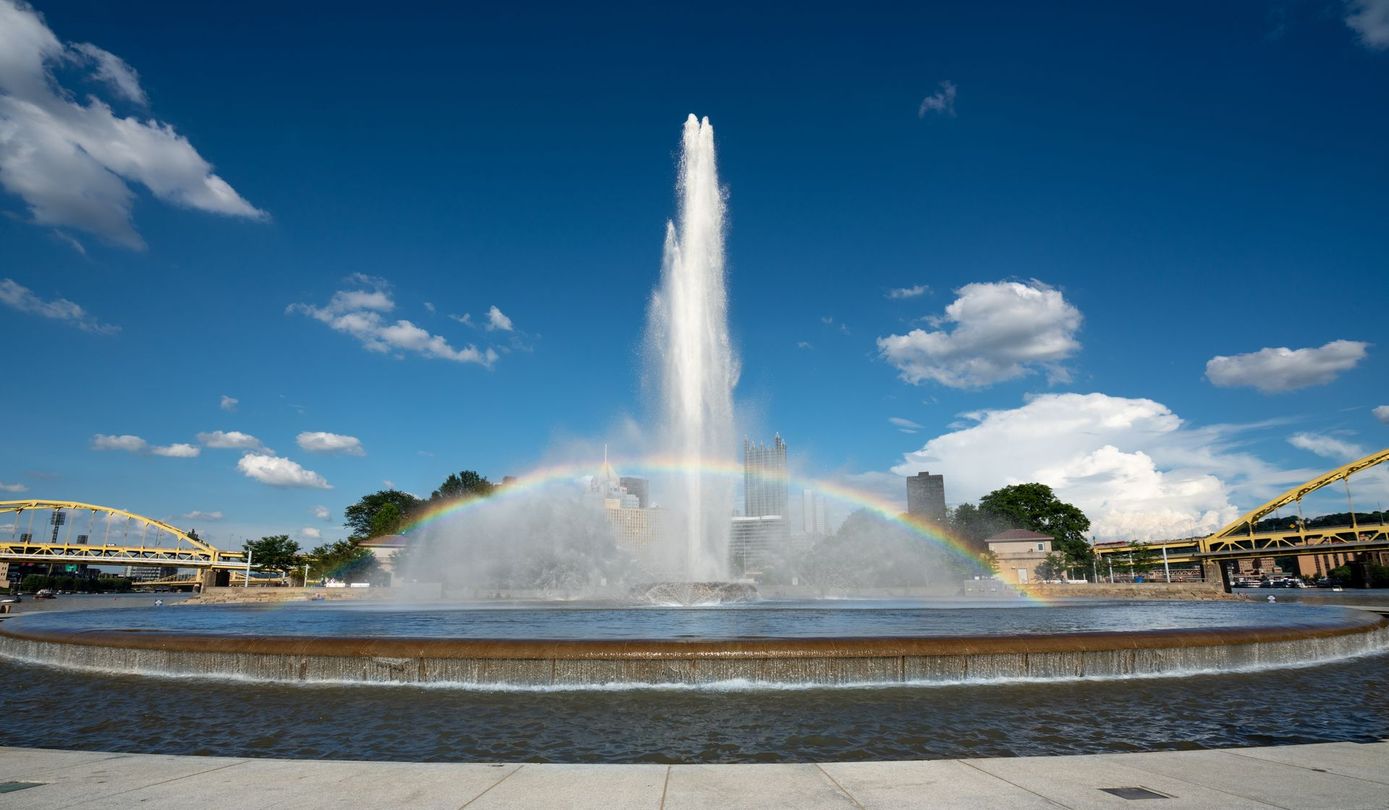 A fountain with a rainbow coming out of it