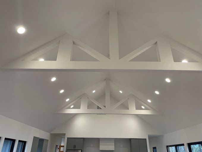 A living room with a vaulted ceiling and white beams.