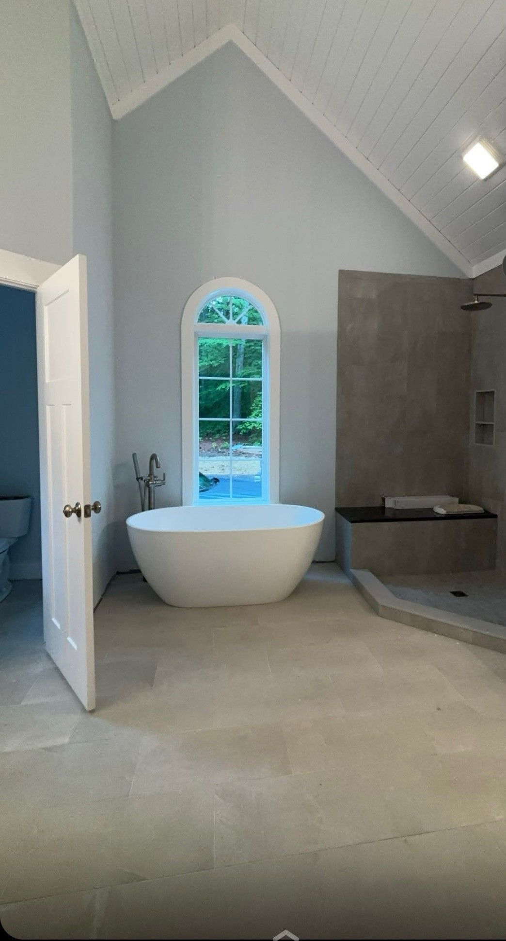 A bathroom with a bathtub , shower , toilet and window.