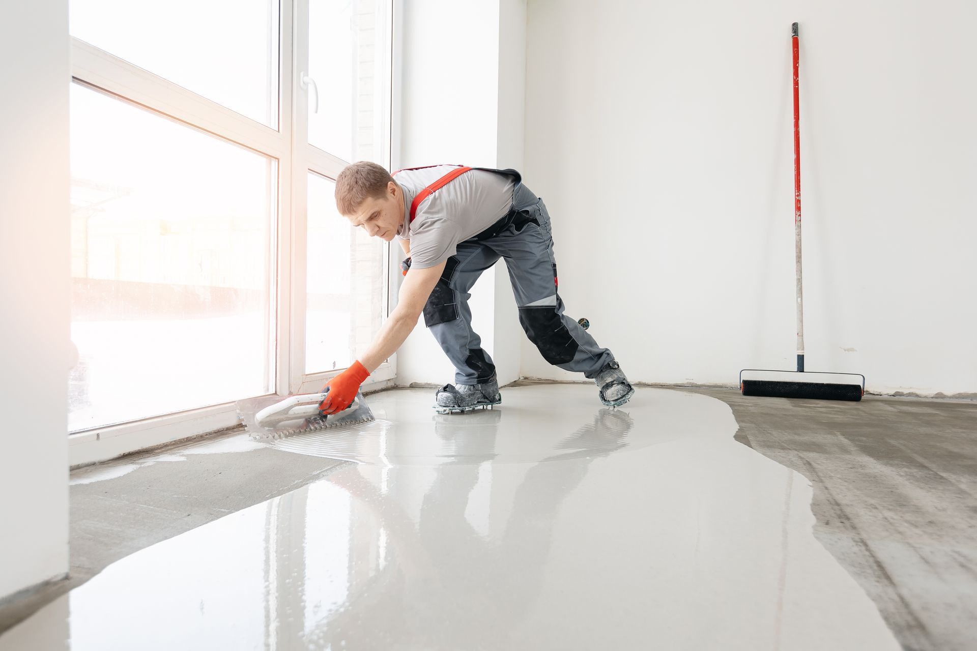 A man is cleaning a floor with a mop.