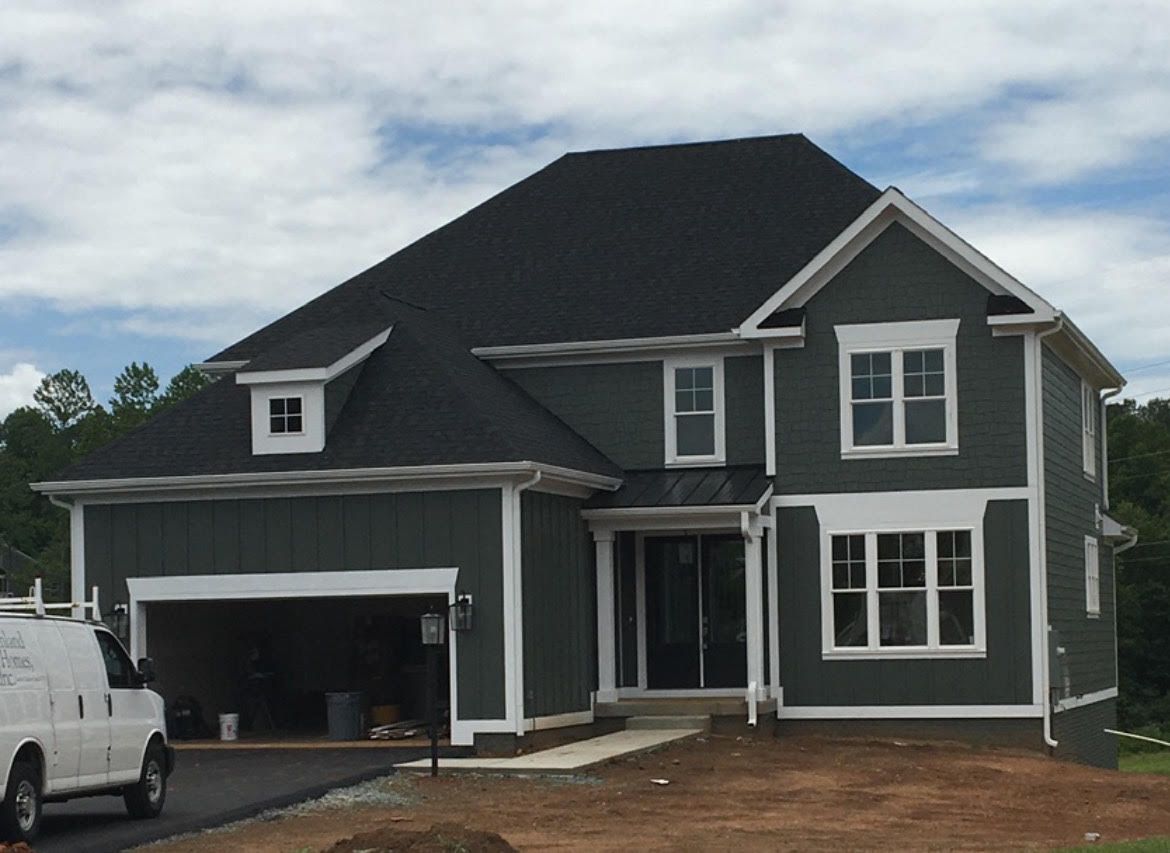 A white van is parked in front of a large house