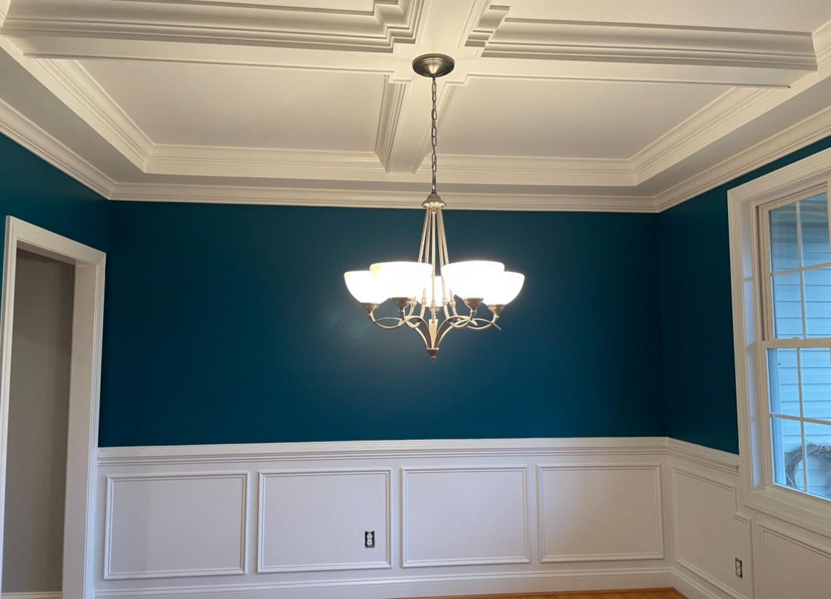 A dining room with blue walls and a chandelier hanging from the ceiling