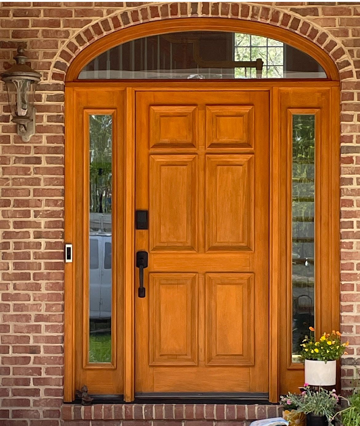 A wooden door with a brick wall behind it