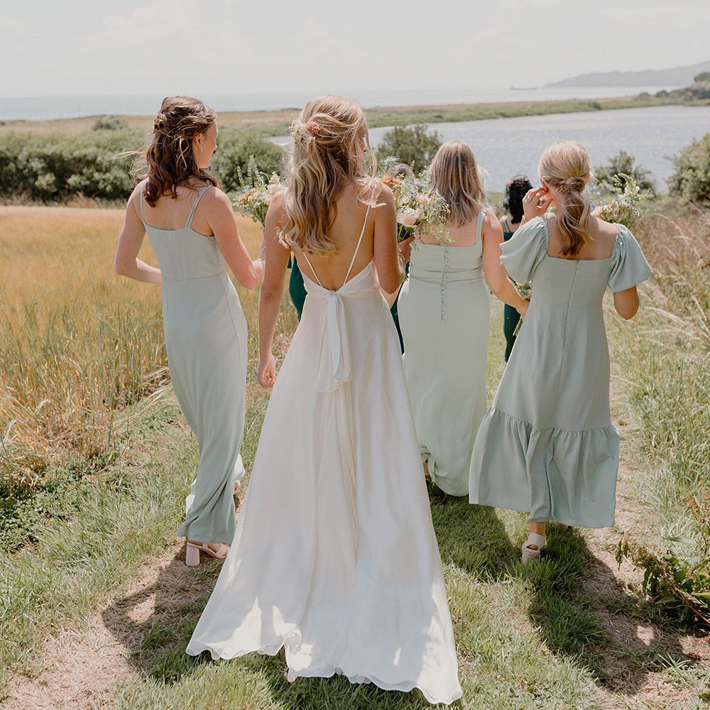 Wedding party walking down to the sea for a beach wedding at The Grain Store Devon