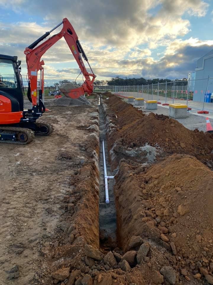 Excavator is Digging a Trench in the Dirt — Donaldson Plumbing & Excavations in Kergunyah, VIC