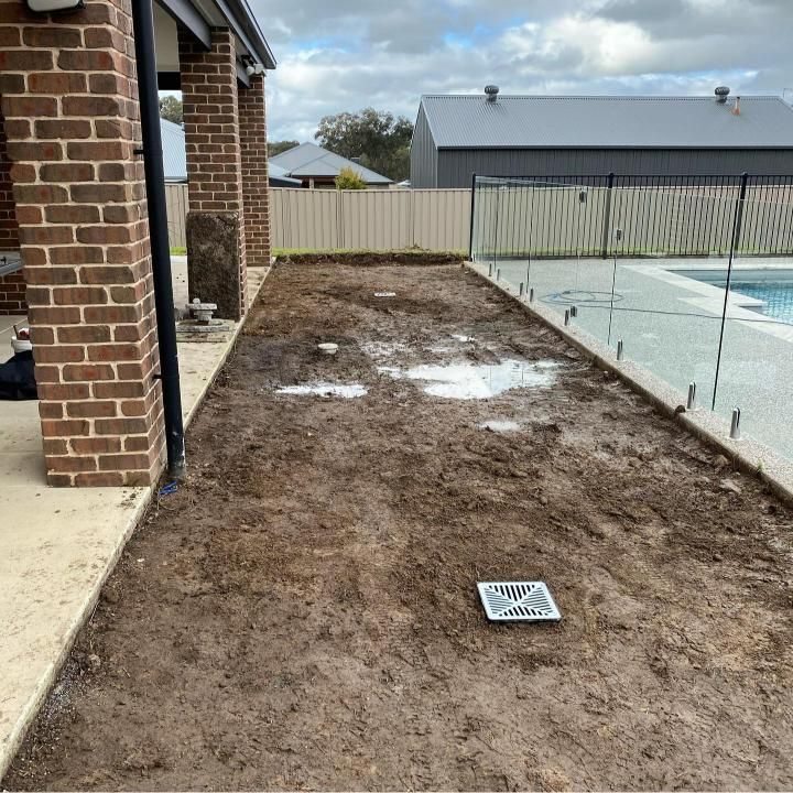 A Dirt Backyard With a Brick House, and Fence in the Background — Donaldson Plumbing & Excavations in Wodonga, VIC