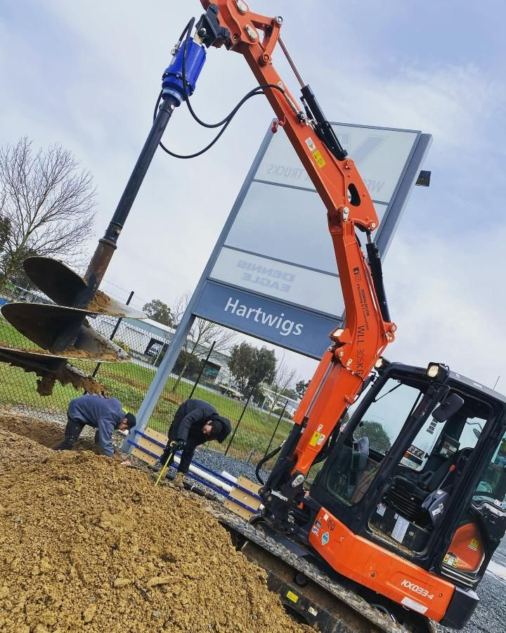 Orange Excavator Drilling a Hole — Donaldson Plumbing & Excavations in Albury, NSW