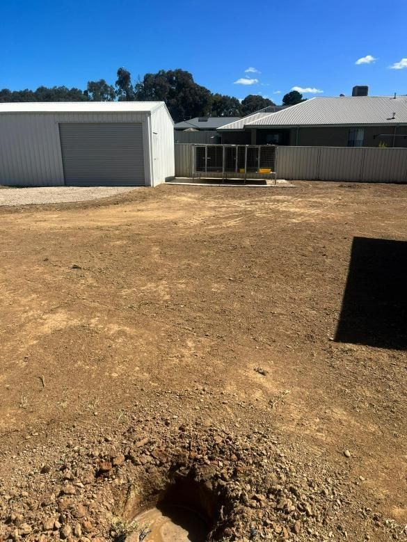 A Backyard With a Shed, Fence, and Bare Dirt — Donaldson Plumbing & Excavations in Albury, NSW