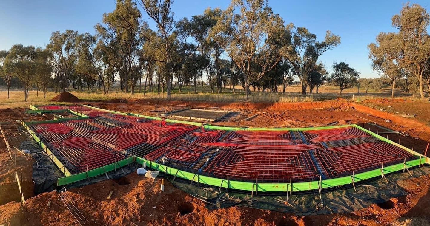 Red Tubing Laid in an Excavated Area — Donaldson Plumbing & Excavations in Baranduda, VIC