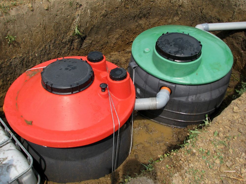 Two Septic Tanks, Red and Green, Buried in a Trench — Donaldson Plumbing & Excavations in Kiewa, VIC