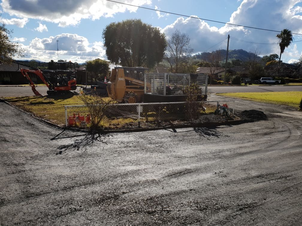 Excavator and Skid Steer Near a Curb, Clearing Land — Donaldson Plumbing & Excavations in Chiltern, VIC