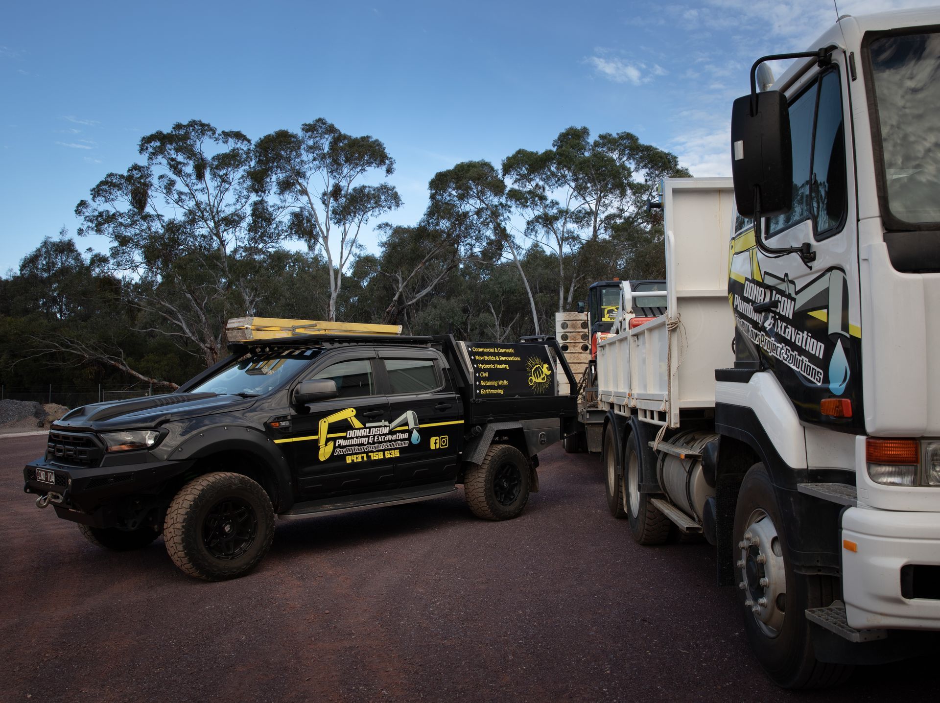 Black Work Truck Next to White Truck — Donaldson Plumbing & Excavations in Baranduda, VIC