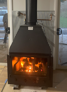 Wood-Burning Fireplace With a Lit Fire, and Black Exterior — Donaldson Plumbing & Excavations in Chiltern, VIC