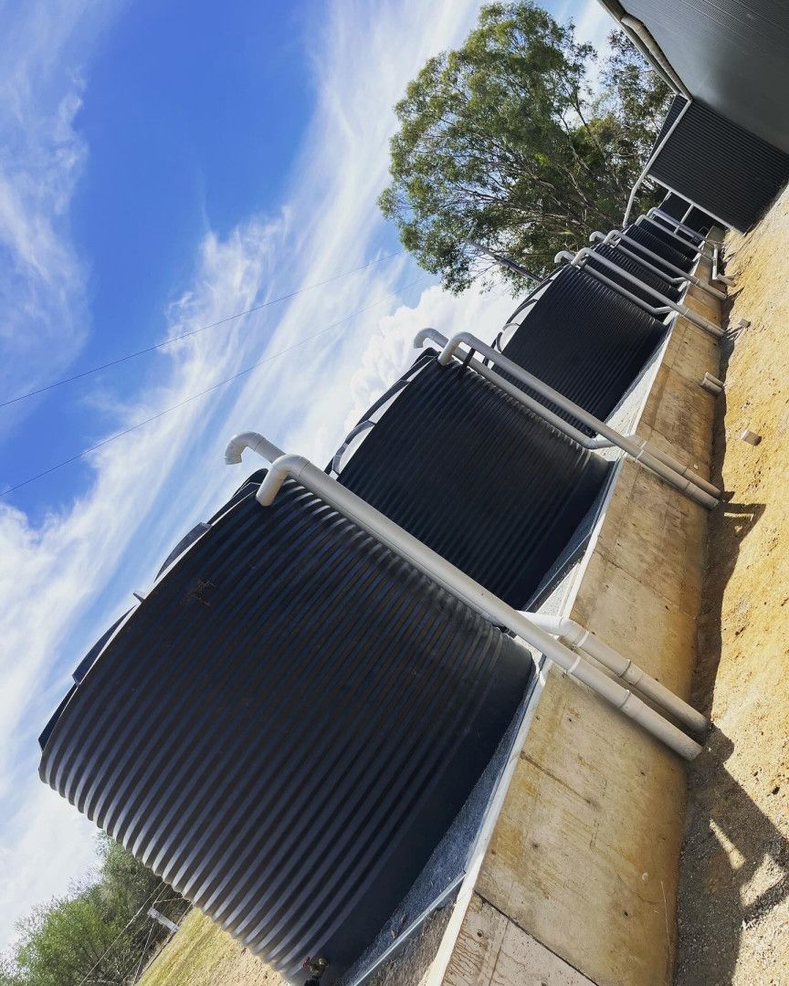 A Row of Dark Corrugated Water Tanks — Donaldson Plumbing & Excavations in Baranduda, VIC