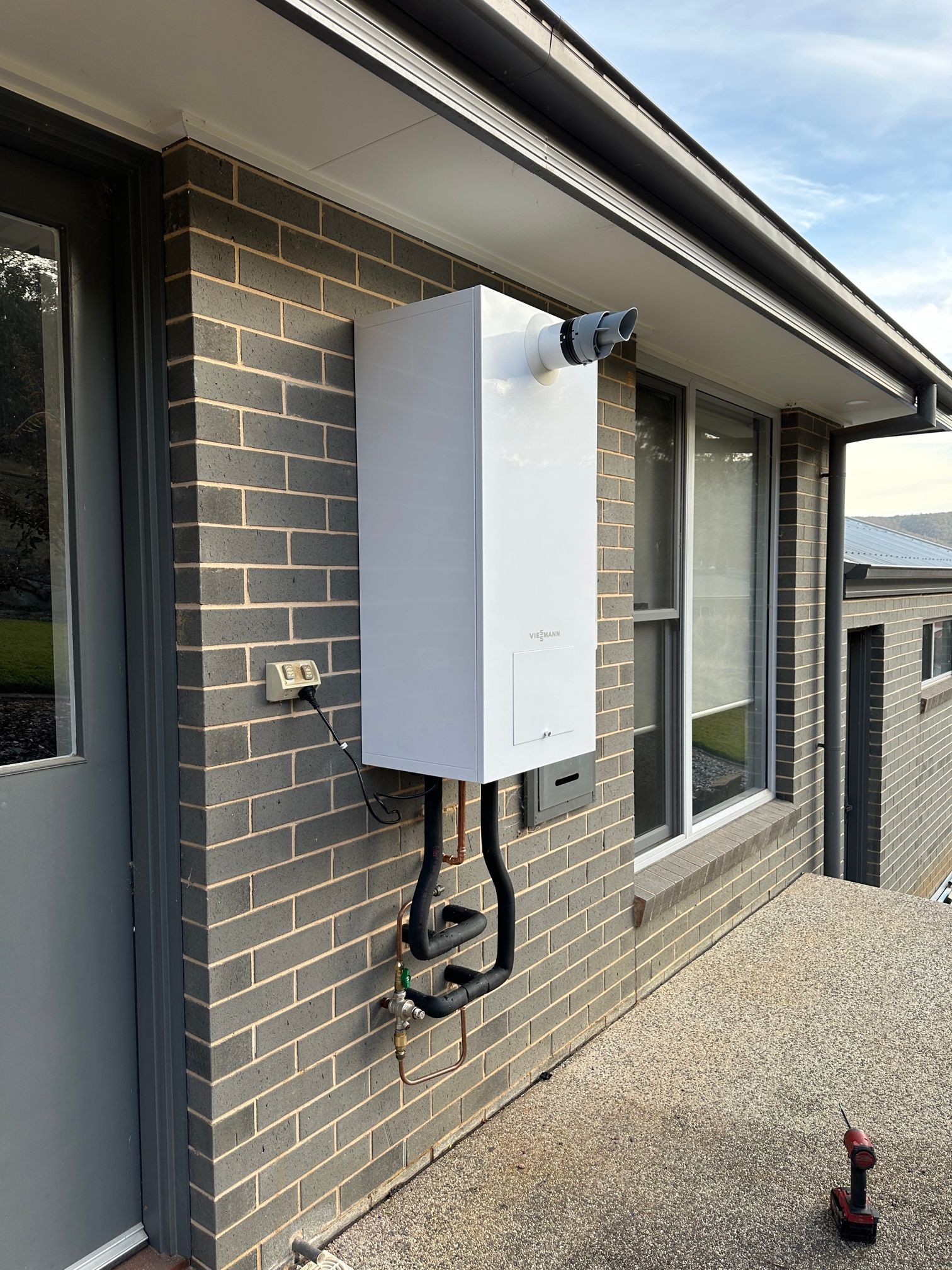White Water Heater Mounted on a Brick Wall — Donaldson Plumbing & Excavations in Baranduda, VIC