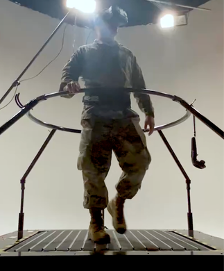 Person standing on a metal platform under bright lights, holding rails in a studio-like setting