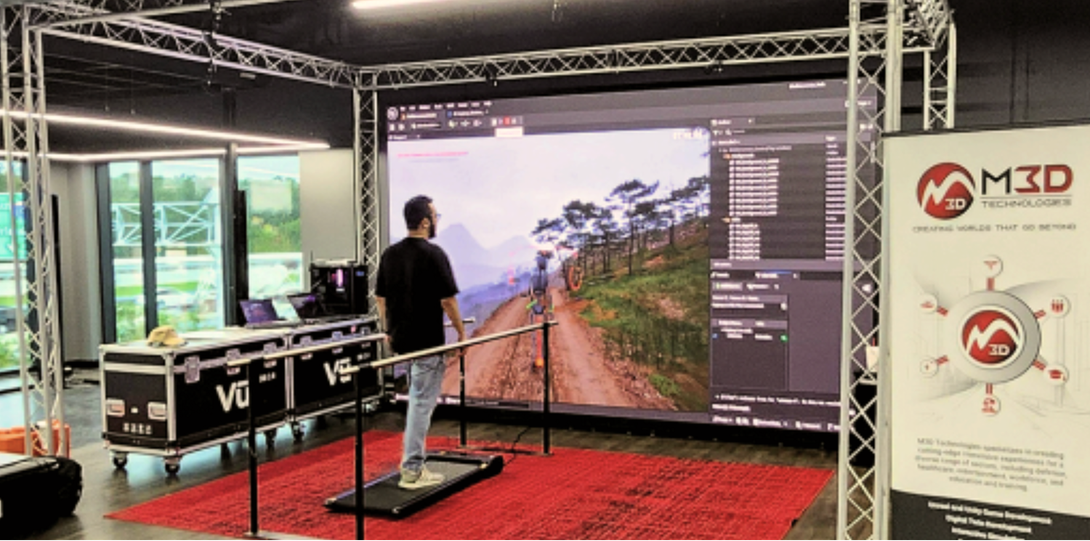 Trade show VR setup with a large screen showing a railway scene and a person standing on the platform.