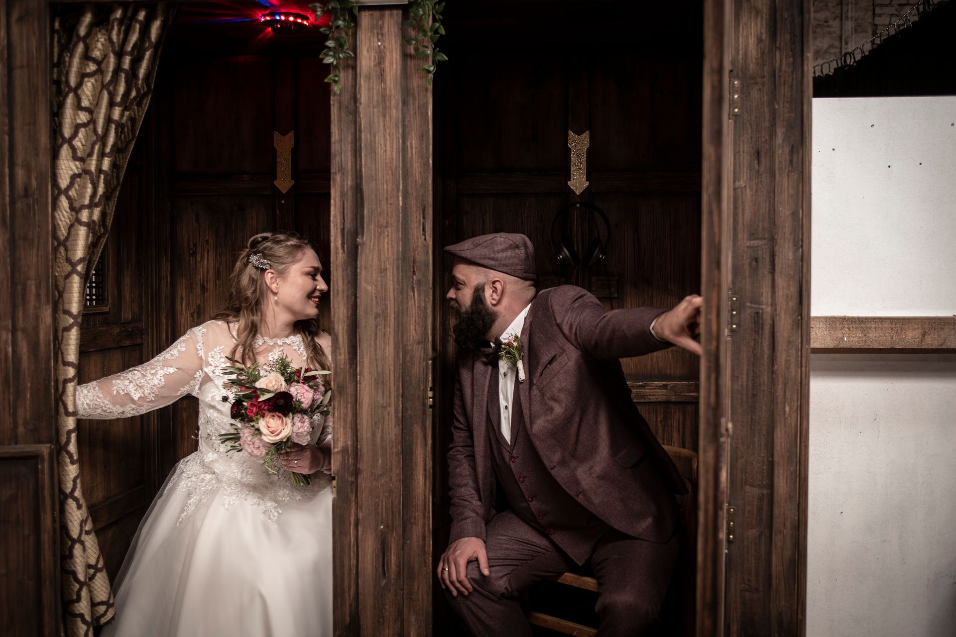 Eine Braut und ein Bräutigam posieren in einer Fotokabine für ein Foto.