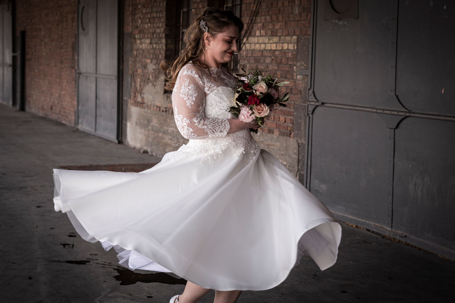 Eine Frau in einem Brautkleid hält einen Blumenstrauß.