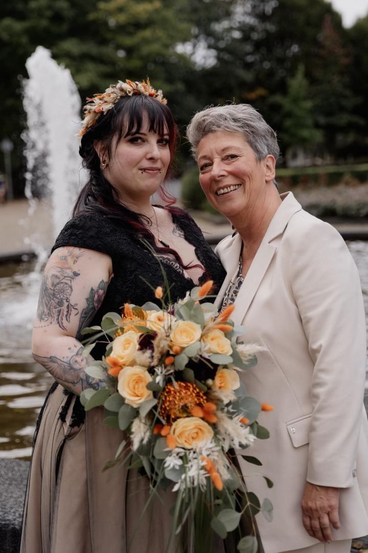 Zwei Frauen posieren vor einem Brunnen für ein Foto.